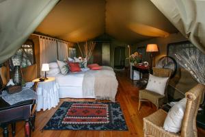 a bedroom with a bed in a tent at Chandelier Game Lodge in Oudtshoorn
