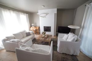 a living room with white couches and a tv at Chambre d'Hôtes Arima in Biarritz