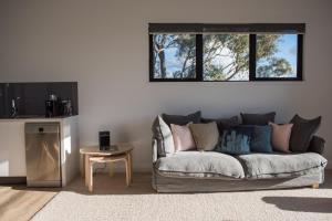 a living room with a couch and a table at Dragonfly Cottages in Orange