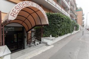uma entrada para um edifício com uma placa em Residence Desenzano em Milão