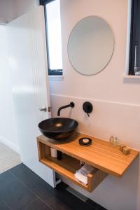 a bathroom with a sink and a mirror at Dragonfly Cottages in Orange