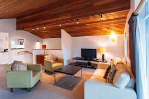 a living room with a couch and chairs and a television at The Cornwall Hotel Spa & Lodges in St Austell