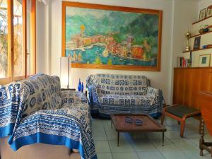 uma sala de estar com um sofá e uma pintura na parede em Baisi Flexyrent em Rapallo