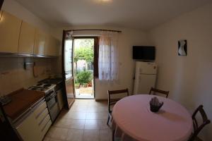 a kitchen with a table and a table and a kitchen with a tableablish at Apartments Neno in Umag