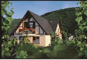 a house with a balcony with red flowers on it at Ferienweingut Pies Ellenz-Poltersdorf in Ellenz-Poltersdorf