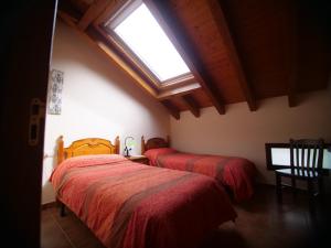 two beds in a room with a window at Albergue de Portilla in Portilla de la Reina