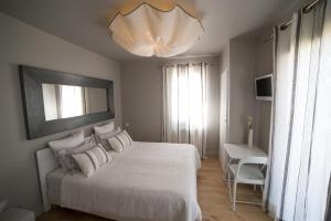 a bedroom with a white bed and a chandelier at Chambre d'Hôtes Arima in Biarritz +13 photos