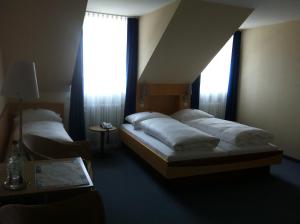 Postel nebo postele na pokoji v ubytování Hotel Hauser an der Universität + 18 fotografií