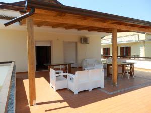 a wooden pergola with a table and chairs on a patio at B&B SoleLuna in Torretta