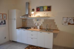 a kitchen with white cabinets and a counter top at Biblos e Mare in Taranto