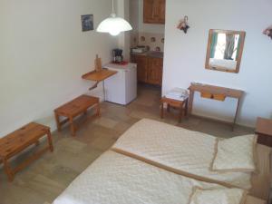 a room with a kitchen with a bed and tables at Sunset in Kalymnos