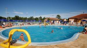 a large swimming pool with people in the water at Residence Sun Hols Villas du Lac - Appartement 2 piéces 4 pers in Soustons