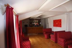 a living room with red chairs and a bar at Hotel Turismo Miranda in Miranda do Douro