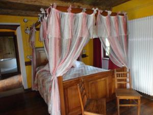 ヴァラッロにあるB&B "La baita delle coccinelle"のベッドルーム1室(天蓋付きの木製ベッド1台付)