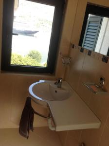 łazienka z umywalką i oknem w obiekcie Villa "M Family" w Kotorze