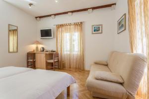 um quarto com uma cama, um sofá e uma secretária em Carrara Accommodation em Split