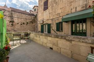 um pátio num edifício antigo com uma mesa e cadeiras em Carrara Accommodation em Split