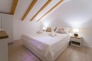 a white bedroom with a large white bed with two lamps at Villa Kristina in Sevid +30 photos