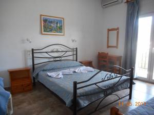 Schlafzimmer mit einem Bett mit blauer Decke in der Unterkunft Guesthouse Christos in Skopelos