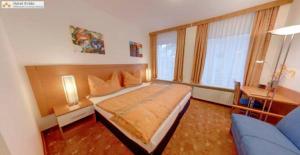 ein Schlafzimmer mit einem Bett und einem blauen Sofa in der Unterkunft Evido Rooms in Salzburg