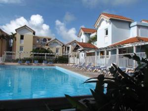 una piscina frente a algunos edificios en HAMEAU DE BEAUREGARD à Sainte Anne, en Sainte-Anne