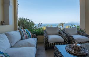 patio z kanapami i stołem oraz widokiem na ocean w obiekcie Diamante Beachfront Suites w mieście Xylokastron