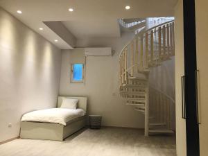 a bedroom with a bed and a spiral staircase at Olosuites in Limassol