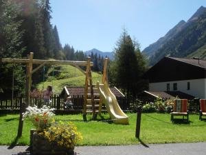 a playground with a slide in the grass at Haus Waldheim in Sankt Leonhard im Pitztal