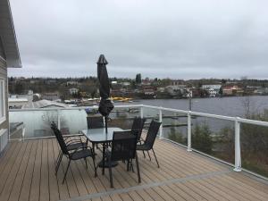 una terraza con mesa, sillas y sombrilla en Howey Bay Motel, en Red Lake