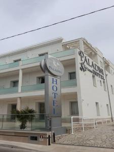 un edificio con una señal delante de él en Hotel Paladini, en Porto Cesareo