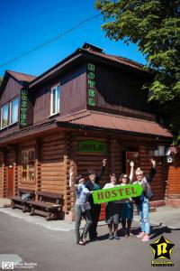 a group of people holding a sign in front of a hostel at Hostel Hola in Chernihiv