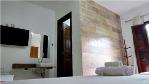um quarto com uma cama e uma casa de banho com um espelho. em Pousada Coqueiro do Caitá em Morro de São Paulo