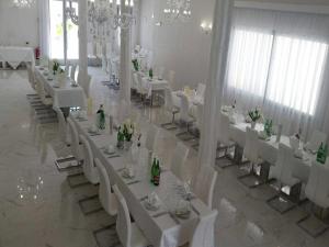 a banquet hall with white tables and white chairs at Hotel Paladini in Porto Cesareo +70 photos
