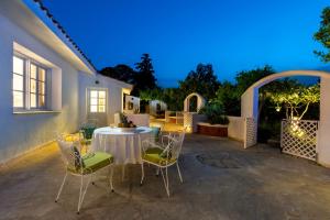 a table and chairs on a patio at night at Amelie Villa in Ixia