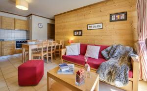 a living room with a red couch and a table at CGH Résidences & Spas Le Ruitor in Sainte-Foy-Tarentaise