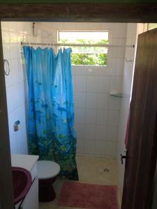 a bathroom with a shower with a blue shower curtain at Recanto Praia do Forte - SC in São Francisco do Sul +35 photos