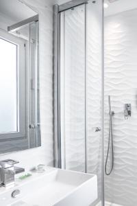 een badkamer met een wastafel en een douche bij Prince Albert Wagram in Parijs