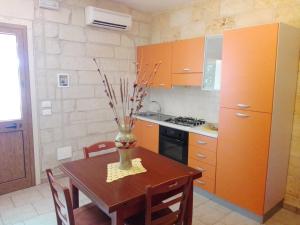 a kitchen with a wooden table and a vase with sticks at Appartamenti turistici Aprile Luca in Borgagne