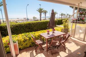 um pátio com uma mesa, cadeiras e um guarda-sol em Seafront L'Estartit Apartments em L'Estartit