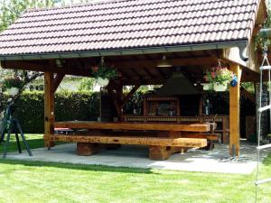 un pabellón de madera con una mesa de picnic en un parque en Chambre d'hotes des Poisets, en Crotenay