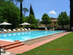 a large swimming pool with chairs and umbrellas at Appartamenti Avanella a 150 mt dalla piscina 150 mt from swimming pool in Certaldo