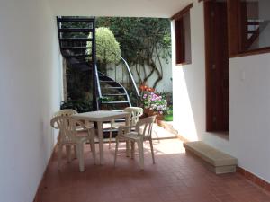 un patio con una mesa y sillas y una escalera en Casa Leo, en Villa de Leyva
