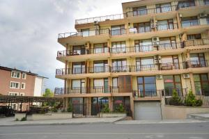 an apartment building with balconies and a street at Studios Grace - Port Tsarevo in Tsarevo