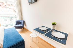 sala de estar con mesa y sofá azul en Porto 271 Mouzinho Apartamentos en Oporto