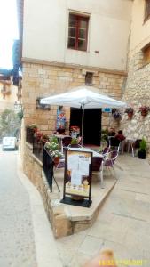 uma mesa com um guarda-chuva em frente a um edifício em Hostal de la Villa Molinos em Molinos