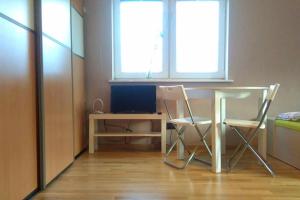 Cette chambre dispose de deux chaises, d'un bureau et d'une fenêtre. dans l'établissement Apartament Monika, à Sopot