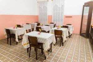 a dining room with tables and chairs with flowers on them at Hotel Palácio - Próx ao Hospital Santa Casa in Porto Alegre