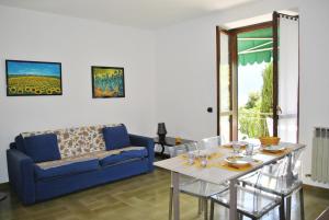 uma sala de estar com um sofá azul e uma mesa em Residence White Beach em Lierna