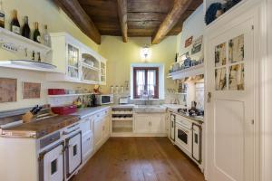 a large kitchen with white cabinets and a wooden ceiling at Villa Elisette by Impero House in Stresa