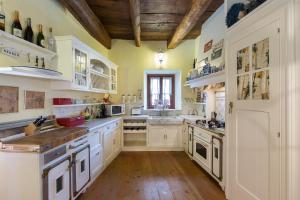 ストレーザにあるVilla Elisette by Impero Houseの白いキャビネットと木製の天井が備わる広いキッチン
